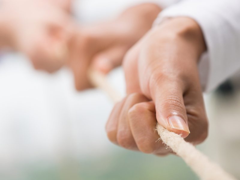 Concept image of business team using a rope as an element of the teamwork on the foreground