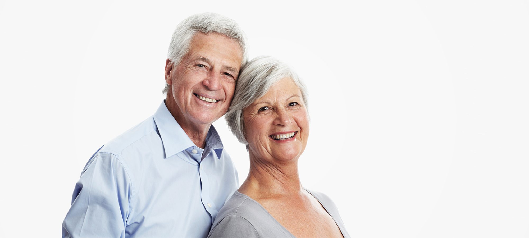 An elderly husband and wife posing happily for the camera